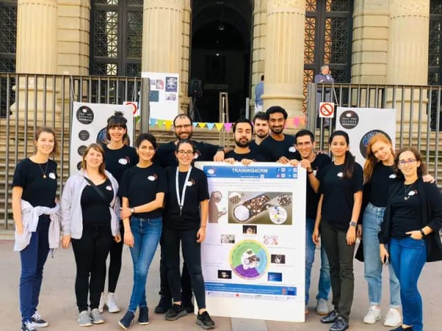 Sandrina with friends and Training4CRM Outreach poster at Barcelona